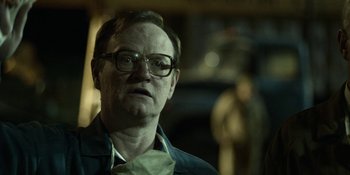 Movie still from “Chernobyl” (2019), directed by Johan Renck – An older man wearing glasses and a green jacket; Close Up shot, Over the shoulder angle
