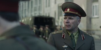 Movie still from “Chernobyl” (2019), directed by Johan Renck – A man in a military uniform standing in front of a crowd; Close Up shot, Over the shoulder angle