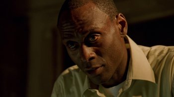 Movie still from “The Wire” (2002), created by David Simon – A person wearing a white shirt; Close Up shot, Low angle