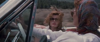 Movie still from “Thelma & Louise” (1991), directed by Ridley Scott – A woman in a white shirt driving a car; Close Up shot, Low angle