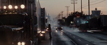 Movie still from “Thelma & Louise” (1991), directed by Ridley Scott – A man standing on the side of a road next to a truck; Wide shot, Low angle