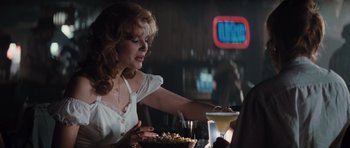 Movie still from “Thelma & Louise” (1991), directed by Ridley Scott – A woman sitting at a table with a plate of food; Medium shot, Over the shoulder angle