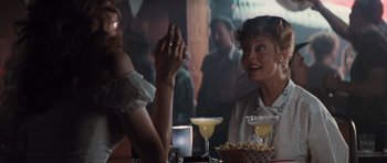 Movie still from “Thelma & Louise” (1991), directed by Ridley Scott – Two women sitting at a table with drinks and popcorn; Medium shot, Over the shoulder angle