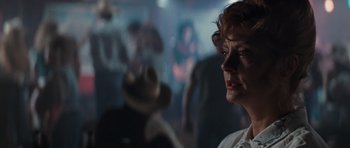 Movie still from “Thelma & Louise” (1991), directed by Ridley Scott – A woman in a white shirt is in a dark room; Close Up shot, Over the shoulder angle