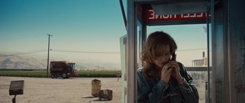 Movie still from “Thelma & Louise” (1991), directed by Ridley Scott – A woman is standing in a phone booth and talking on a phone; Medium shot, High angle
