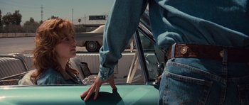 Movie still from “Thelma & Louise” (1991), directed by Ridley Scott – A man standing on the hood of a car next to a woman; Medium shot, Over the shoulder angle