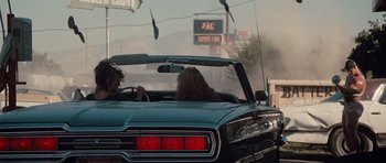 Movie still from “Thelma & Louise” (1991), directed by Ridley Scott – Two people in the back seat of a car driving down a street; Wide shot, Over the shoulder angle