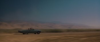 Movie still from “Thelma & Louise” (1991), directed by Ridley Scott – Two people in a car driving down a dirt road; Extreme Wide shot, Low angle