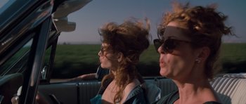 Movie still from “Thelma & Louise” (1991), directed by Ridley Scott – Two women sitting in the back seat of a car; Close Up shot, Low angle