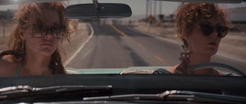 Movie still from “Thelma & Louise” (1991), directed by Ridley Scott – A woman driving a car on a road; Medium shot, Over the shoulder angle