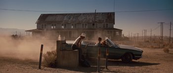 Movie still from “Thelma & Louise” (1991), directed by Ridley Scott – Two people sitting on a bench near a boat; Wide shot, Low angle