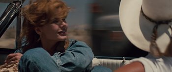 Movie still from “Thelma & Louise” (1991), directed by Ridley Scott – A woman sitting on a couch in front of a window; Close Up shot, Over the shoulder angle