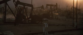Movie still from “Thelma & Louise” (1991), directed by Ridley Scott – A group of oil pumps sitting in the middle of an oil field; Extreme Wide shot, High angle