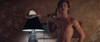 Movie still from “Thelma & Louise” (1991), directed by Ridley Scott – A shirtless man dries his hair with a blow dryer; Medium shot, Low angle