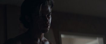 Movie still from “Thelma & Louise” (1991), directed by Ridley Scott – A man with a beard is standing in a dark room; Close Up shot, Over the shoulder angle