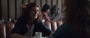 Movie still from “Thelma & Louise” (1991), directed by Ridley Scott – A group of people sitting at a table with a cup of coffee; Medium shot, Over the shoulder angle