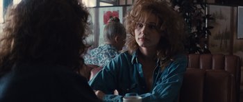Movie still from “Thelma & Louise” (1991), directed by Ridley Scott – A woman sitting at a table with a cup of coffee; Close Up shot, Over the shoulder angle