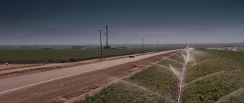 Movie still from “Thelma & Louise” (1991), directed by Ridley Scott – An oil rig in the distance behind an empty road; Extreme Wide shot, High angle