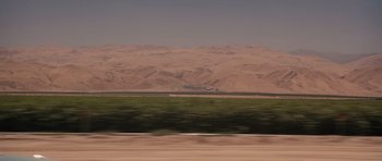 Movie still from “Thelma & Louise” (1991), directed by Ridley Scott – A view from a car looking at a desert; Extreme Wide shot, High angle