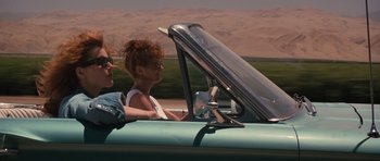 Movie still from “Thelma & Louise” (1991), directed by Ridley Scott – A man and a woman driving a car in the desert; Medium shot, Low angle