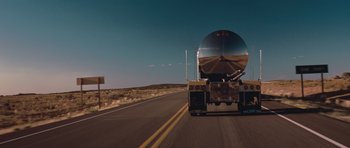 Movie still from “Thelma & Louise” (1991), directed by Ridley Scott – A truck driving down a road near a hill; Extreme Wide shot, Low angle