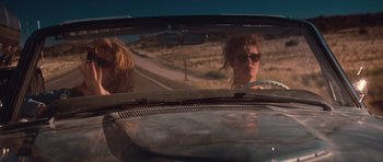 Movie still from “Thelma & Louise” (1991), directed by Ridley Scott – Two people in the back of a car looking at a road; Medium shot, Low angle