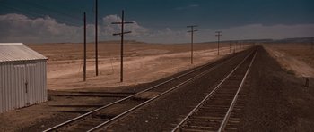 Movie still from “Thelma & Louise” (1991), directed by Ridley Scott – A view of a train track with power lines in the background; Extreme Wide shot, High angle