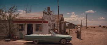 Movie still from “Thelma & Louise” (1991), directed by Ridley Scott – An old car parked in front of an old building; Extreme Wide shot, High angle