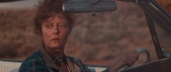 Movie still from “Thelma & Louise” (1991), directed by Ridley Scott – A woman sitting in the drivers seat of a car; Close Up shot, Low angle