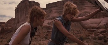 Movie still from “Thelma & Louise” (1991), directed by Ridley Scott – Two women are standing in the desert looking at each other; Medium shot, Low angle