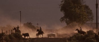 Movie still from “Thelma & Louise” (1991), directed by Ridley Scott – A man on a horse rides down a dirt road; Extreme Wide shot, Low angle
