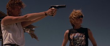 Movie still from “Thelma & Louise” (1991), directed by Ridley Scott – A person holding a gun up to a woman's face; Medium shot, Low angle