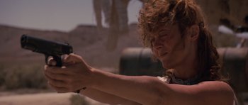 Movie still from “Thelma & Louise” (1991), directed by Ridley Scott – A woman holding a gun in her hands; Close Up shot, Low angle