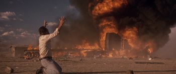 Movie still from “Thelma & Louise” (1991), directed by Ridley Scott – A person standing in front of a fire; Wide shot, Low angle