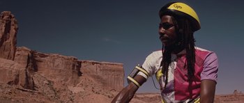 Movie still from “Thelma & Louise” (1991), directed by Ridley Scott – A man with long black hair wearing a yellow hat; Close Up shot, Low angle