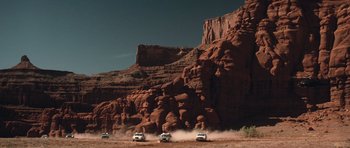 Movie still from “Thelma & Louise” (1991), directed by Ridley Scott – A group of cars driving down a dirt road; Extreme Wide shot, Low angle