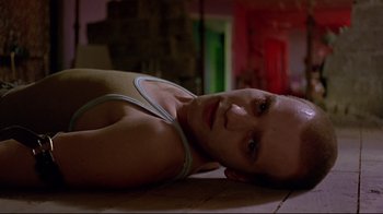 Movie still from “Trainspotting” (1996), directed by Danny Boyle – A man laying on the ground looking at the camera; Close Up shot, High angle
