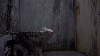 Movie still from “Trainspotting” (1996), directed by Danny Boyle – A hand reaching out of a bowl in a room; Medium shot, Overhead angle