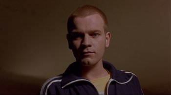 Movie still from “Trainspotting” (1996), directed by Danny Boyle – A man with a shaved head and a yellow t - shirt; Close Up shot, Low angle