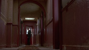 Movie still from “Trainspotting” (1996), directed by Danny Boyle – A man standing in a hallway of a building; Wide shot, Low angle