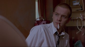 Movie still from “Trainspotting” (1996), directed by Danny Boyle – A man in a white dress shirt and tie smoking a cigarette; Close Up shot, Over the shoulder angle