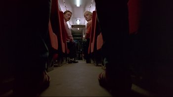 Movie still from “Trainspotting” (1996), directed by Danny Boyle – Two men are reflected in a mirror on a train; Wide shot, Low angle