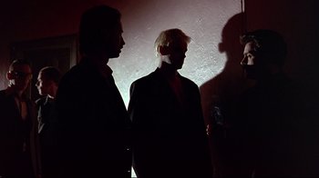 Movie still from “Trainspotting” (1996), directed by Danny Boyle – A group of men standing next to each other in a room; Medium shot, Low angle