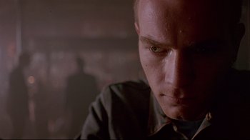 Movie still from “Trainspotting” (1996), directed by Danny Boyle – A man's face in a dark room; Close Up shot, Low angle
