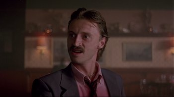 Movie still from “Trainspotting” (1996), directed by Danny Boyle – A person wearing a suit and tie; Close Up shot, Low angle