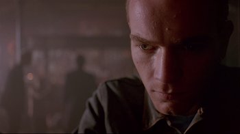 Movie still from “Trainspotting” (1996), directed by Danny Boyle – A man's face in a dark room; Close Up shot, Low angle