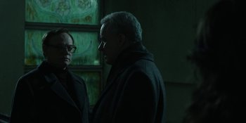 Movie still from “Chernobyl” (2019), directed by Johan Renck – Two men standing next to each other in a dark room; Medium shot, Over the shoulder angle