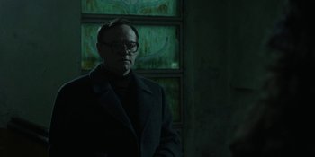 Movie still from “Chernobyl” (2019), directed by Johan Renck – A man wearing glasses standing in front of a window; Medium shot, Low angle