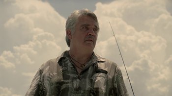 Movie still from “True Detective” (2014), created by Issa López – An older man with a fish rod in his mouth; Close Up shot, Low angle