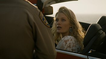 Movie still from “True Detective” (2014), created by Issa López – A beautiful woman sitting in the back seat of a car; Close Up shot, Over the shoulder angle